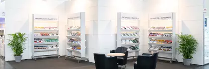 Stand with chairs, table and shelves displaying trade press brochures.