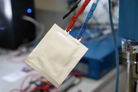 Ein weißer Beutel hängt an Kabeln in einem Labor, sieht aus wie eine Pouchzelle.