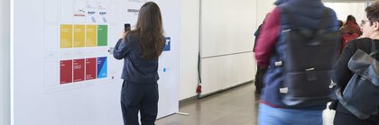 Eine Person steht vor dem Hallenplan der f.re.e, IMOT und MAT 2024 und macht ein Handyfoto