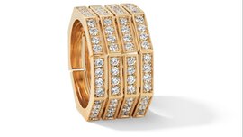 A wide gold ring in the shape of a honeycomb, divided into four equal sections and set with numerous diamonds.