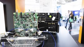 Close-up of an electronic circuit board on display, wired to another device.
