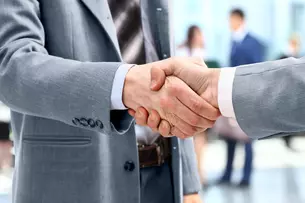 Close-up of a handshake between two people in business attire.