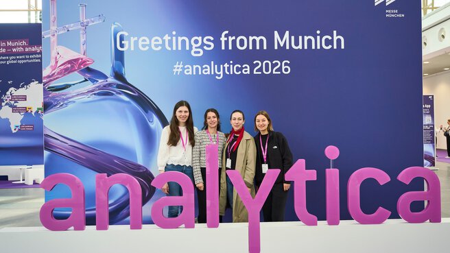 Four women in front of the analytica selfie wall in Munich