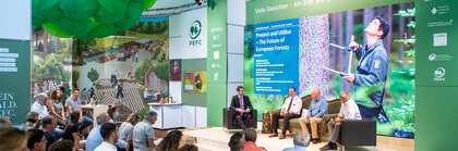 Four men sitting on a sofa during a supporting program event at INTERFORST on stage