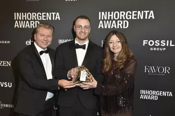 Drei Personen halten lächelnd die Trophäe der Kategorie „Design Newcomer of the Year“ vor einer Logowand auf der INHORGENTA AWARD-Gala.