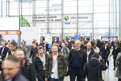 Auf dem Foto ist eine große Gruppe von Menschen zu sehen, die gemeinsam in eine Messehalle strömt, um die Fachmesse electronica zu besuchen.