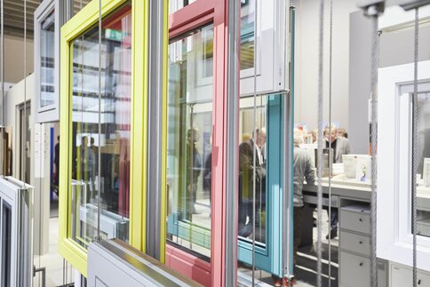 Colorful window frames in an exhibition room with people in the background.
