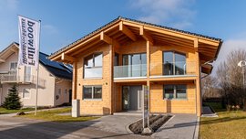 Modernes Holzhaus mit großen Fenstern, zwei Stockwerken auf dem Gelände des Bauzentrum Poing.