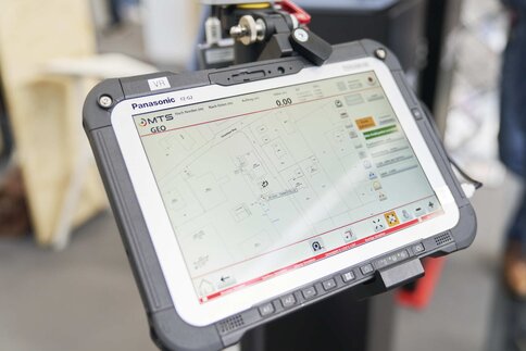 Auf einem Ständer montiertes Tablet auf dem eine Karte mit Straßen und Gebäudeumrissen angezeigt wird.