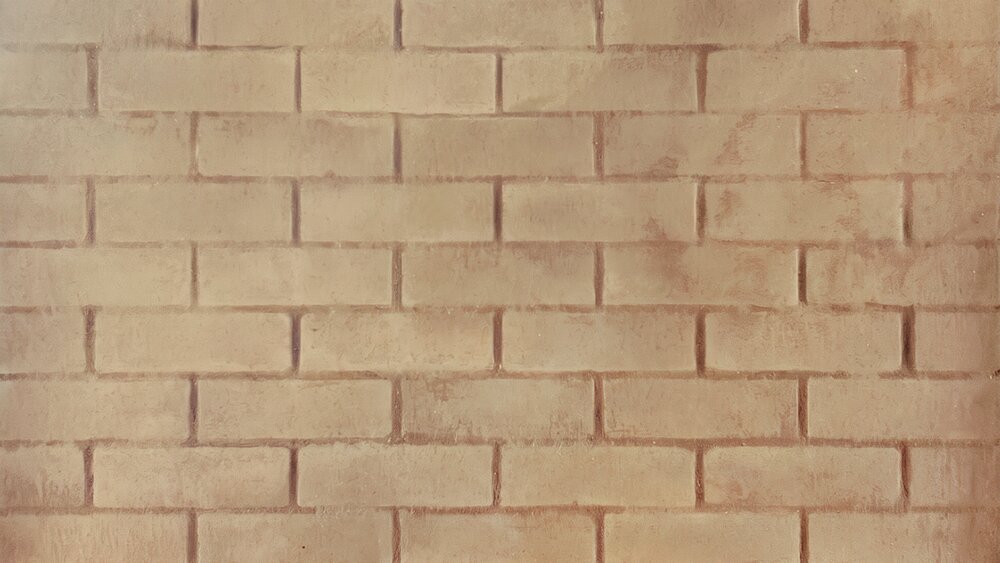 Uniform surface of light brown bricks in horizontal rows, with slightly varied tones, showing the texture of a wall.