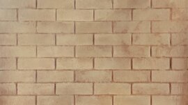 Uniform surface of light brown bricks in horizontal rows, with slightly varied tones, showing the texture of a wall.