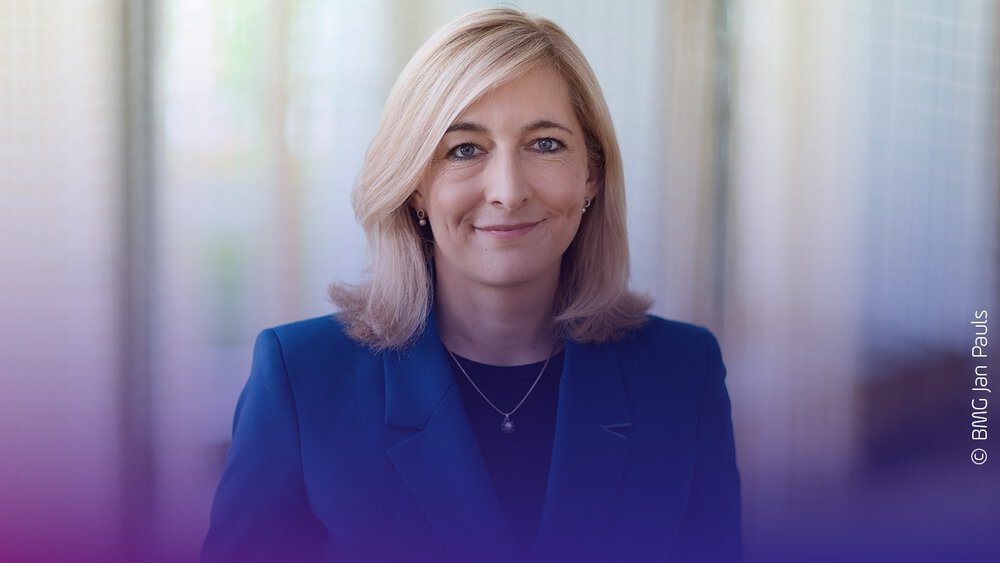 Eine Frau in einem blauen Blazer lächelt mit Text: Schirmherrschaft und Keynote 2027 Nina Warken, DMEA Connecting Digital Health