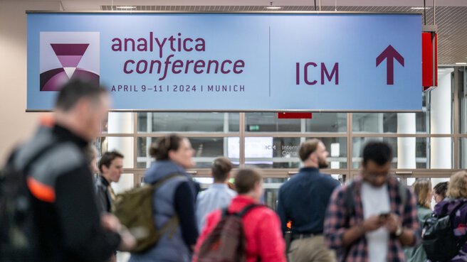 Personen folgen einem Schild mit einem Pfeil Richtung ICM