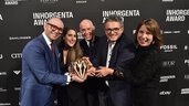A group of five people smilingly hold the “High Jewelry of the Year” trophy in front of a logo wall with “INHORGENTA AWARD” logos.