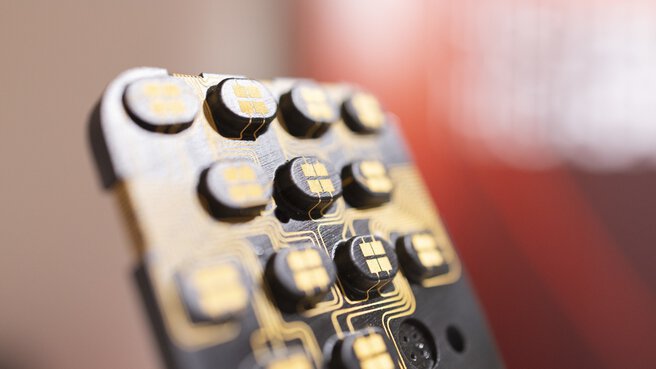 Nahaufnahme einer Art Fernbedienung mit Tasten, die mit goldenen Schaltkreisen bedruckt ist.