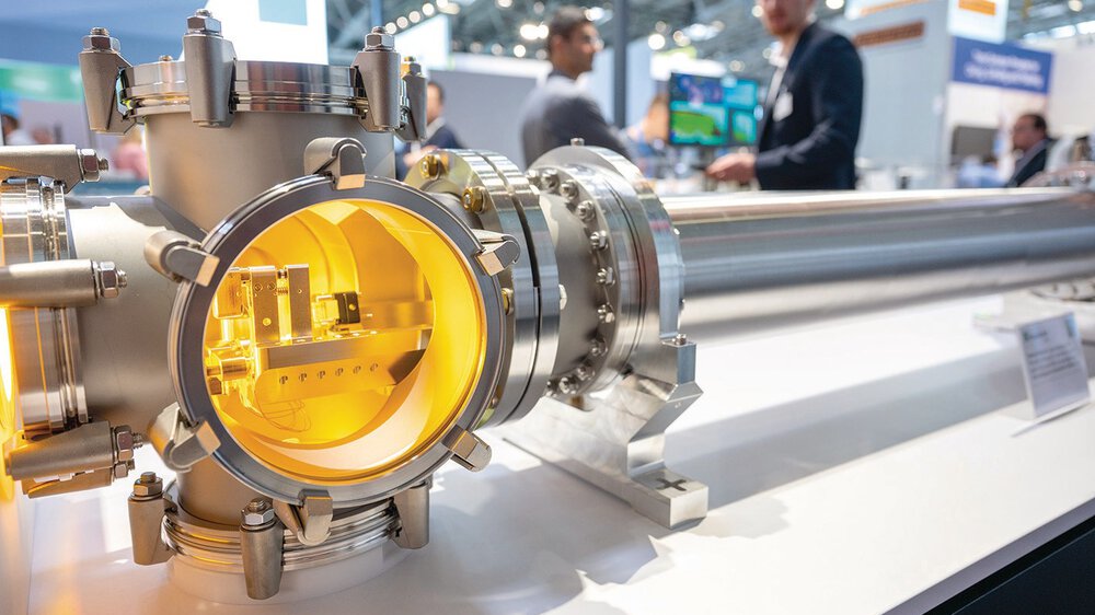 Nahaufnahme einer großen industriellen Metallkammer auf der LAS mit verschwommenen Besuchern im Hintergrund.