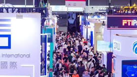 Numerous visitors to transport logistic CHINA walk across a red carpet laid out between many colourful exhibition stands.