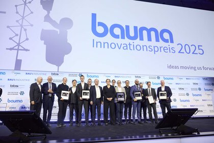 Gruppe der Sieger und Laudatoren auf einer Bühne vor  „bauma Innovationspreis 2025“ -Logo.