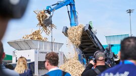 Mobile Lindner shredder processing waste wood at the IFAT outdoor area, observed by spectators.