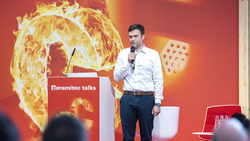 Ein Mann spricht bei ceramitec talks auf der Bühne in ein Mikrofon.