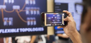 Smartphone filmt ein Display mit grafischer Darstellung von Topologien.