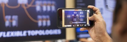 Smartphone filmt ein Display mit grafischer Darstellung von Topologien.