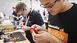 Zwei Personen arbeiten bei einem Maker-Event an Elektronikprojekten und nehmen Leiterplatten genau unter die Lupe.