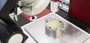 Image from productronica, a close-up of a measuring probe hovering over a fixed plaque.
