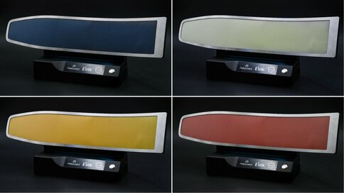 Functional Decor Surface mit E-Ink Technologie, dargestellt in vier Farbzuständen (Blau, Weiß, Gelb, Rot) auf schwarzem Sockel.