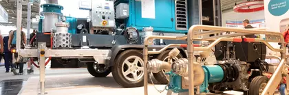 Mobile pumps in different sizes, exhibited on a trade fair stand.