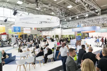 Besucher auf einer Fachmesse zum Thema Entsorgung, Wasser- und Kreislaufwirtschaft. Im Vordergrund finden Gespräche und Networking in einer einladenden Lounge-Atmosphäre statt. Über den Ständen sind Logos von Ausstellern wie BDE und VBS zu sehen. Im Hintergrund präsentieren verschiedene Unternehmen und Verbände nachhaltige Lösungen und Innovationen.