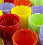 Colorful plastic cups red, orange, yellow, green and purple are stacked.