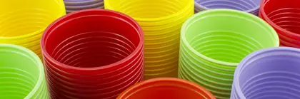 Colorful plastic cups red, orange, yellow, green and purple are stacked.
