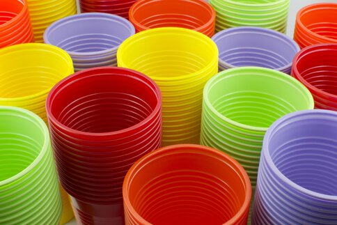 Colorful plastic cups red, orange, yellow, green and purple are stacked.