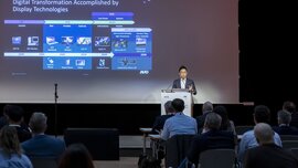 Ein Mann steht an einem Podium vor Publikum der LOPEC. Hinter ihm ist eine Präsentationsfolie an einer Leinwand zu sehen.