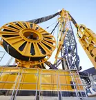 Close-up of a large yellow industrial machine with complex mechanical components and cylindrical structures.