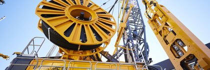 Nahaufnahme einer großen gelben Industriemaschine mit komplexen mechanischen Bauteilen und zylindrischen Strukturen.