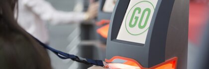 A trade show visitor scans her admission ticket at a turnstile
