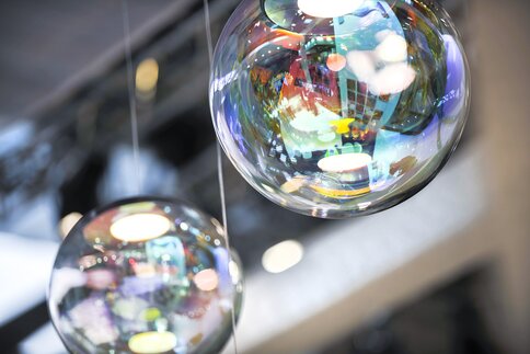 Two large, reflective glass balls with colorful lights and shapes reflected on their surface.