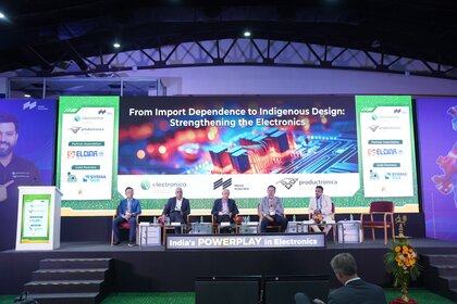 Industry leaders participate in a panel discussion at electronica India and productronica India. Five speakers are seated on stage beneath a large screen highlighting indigenous electronics design and innovation