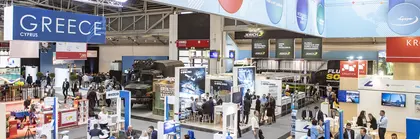 Bird's eye view of the interior of a well-attended exhibition hall at transport logistic with numerous posters, stands and networking opportunities.