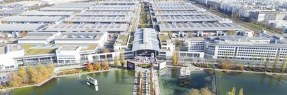 Aerial view of the Messesee with access to the West Entrance, as well as the exhibition halls and the Messeturm in the distance.