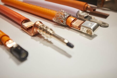 Close-up of orange high-voltage cables with different connections.