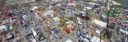 Aerial view of bauma with many stands, construction machines and cranes on the grounds of Messe München.