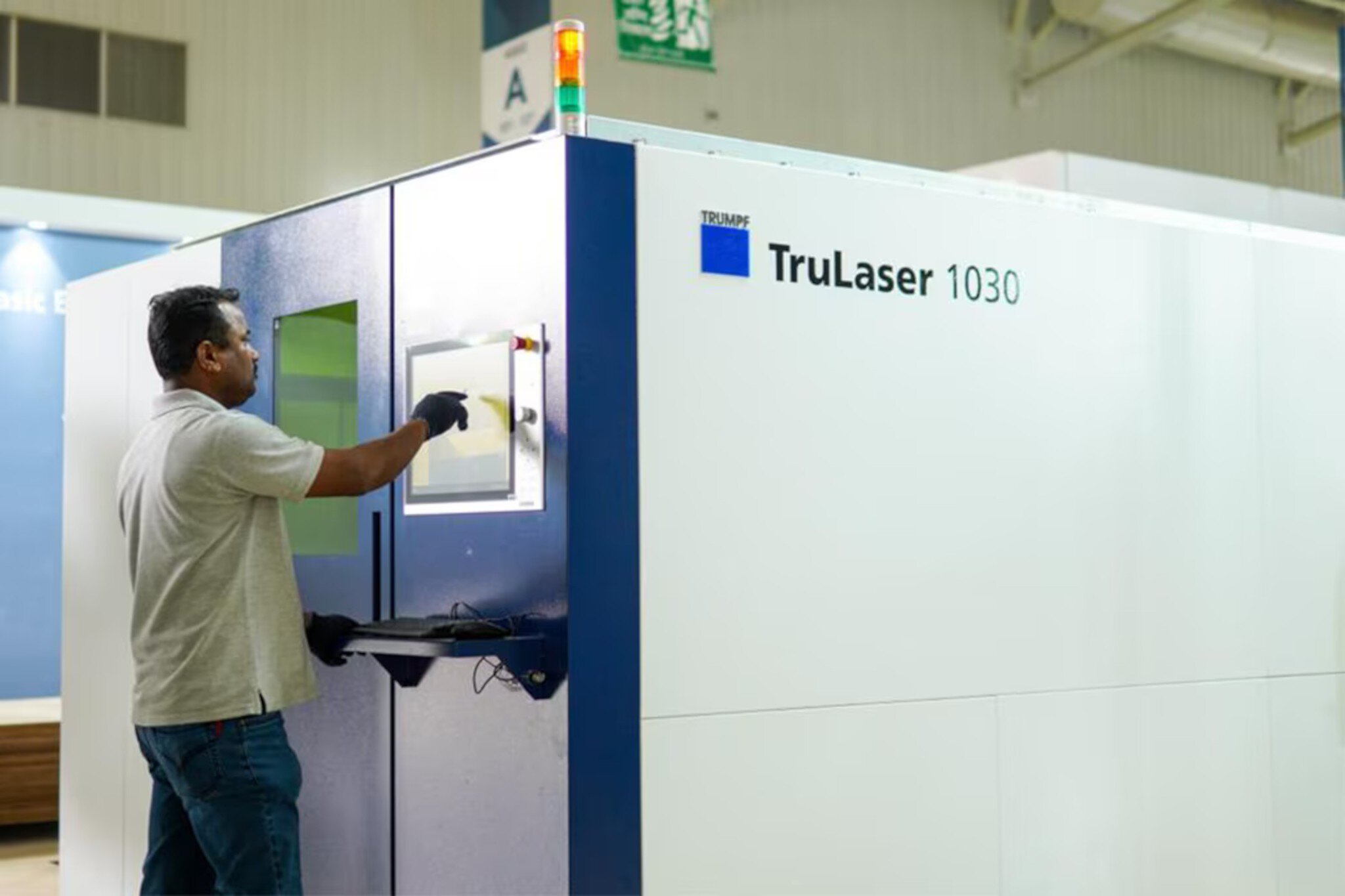 Person, die an einem Messestand den Touchscreen eines aufgebauten TruLaser 1030 bedient.
