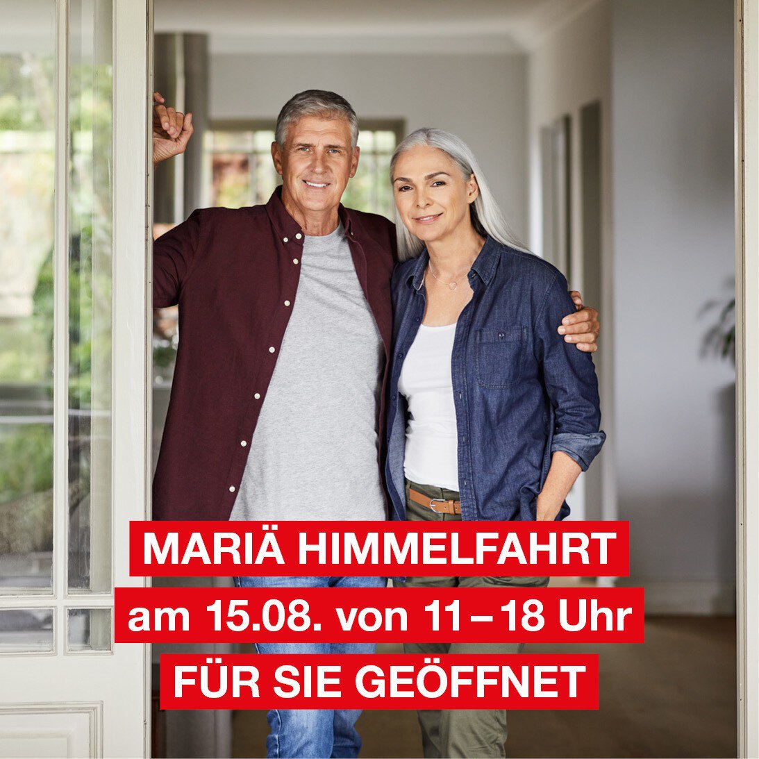 Ein lächelndes älteres Ehepaar steht im hellen Eingangsbereich eines Hauses. Der Text lautet: Mariä Himmelfahrt am 15.08. von 11–18 Uhr FÜR SIE GEÖFFNET..