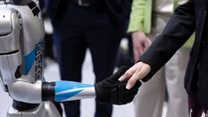 Ein Roboter schüttelt einer Person die Hand