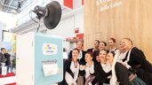 Several women in traditional dress pose together in front of a photo booth at the “Croatia – Full of Life” exhibition stand and have a souvenir photo taken.