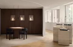 Moderner Ausstellungsraum mit Schmuckauslage, einem runden Tisch mit Stühlen und sanftem Tageslicht durch große Fenster.