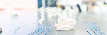 White miniature excavator on metal surface on the Hexagon stand at bauma 2022